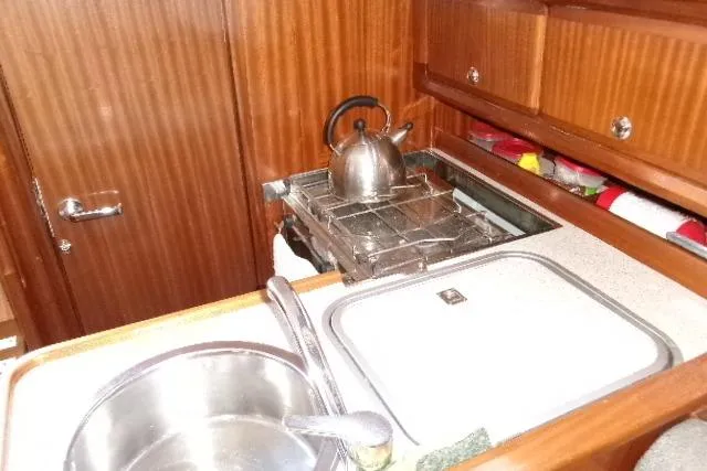 Slide: The Image of Compact kitchen area in a 2000 Bavaria Yachts sloop, featuring a sink and stove. - 1