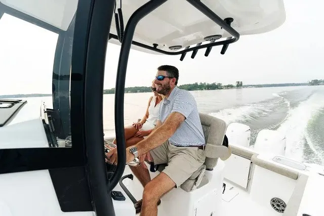 Slide: The Image of A man steers a Sea Hunt Gamefish 25 boat on calm waters. - 5