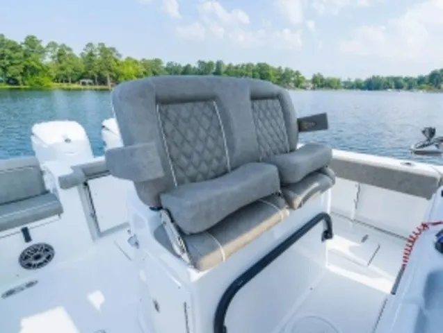 Slide: The Image of The image shows the seating area of a 2027 Sea Hunt Gamefish 25 boat on a calm lake. - 8
