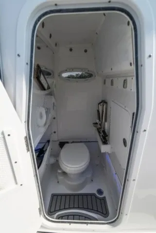 Slide: The Image of The image shows a compact boat toilet with a porthole and white walls. - 14
