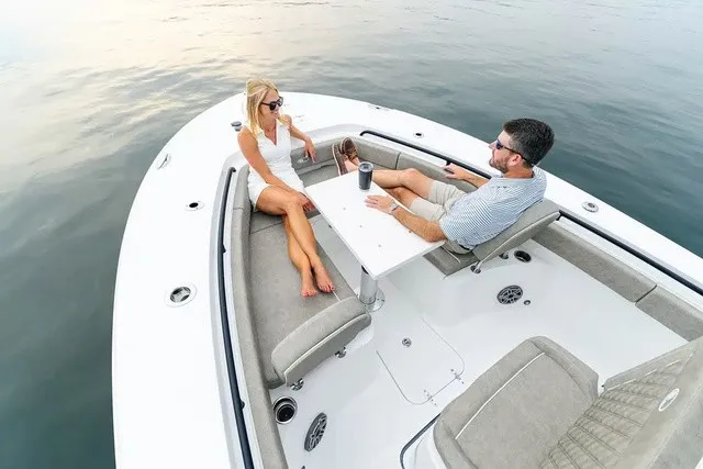 Slide: The Image of Two people relax on a Sea Hunt Gamefish 25 boat floating on calm water. - 16
