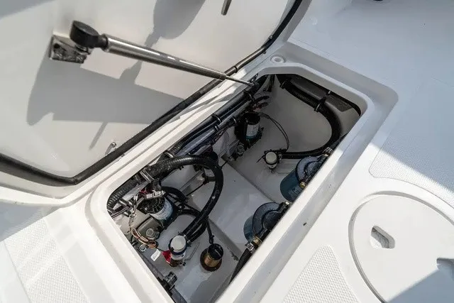 Slide: The Image of An open compartment on a boat reveals hoses and mechanical components. - 13