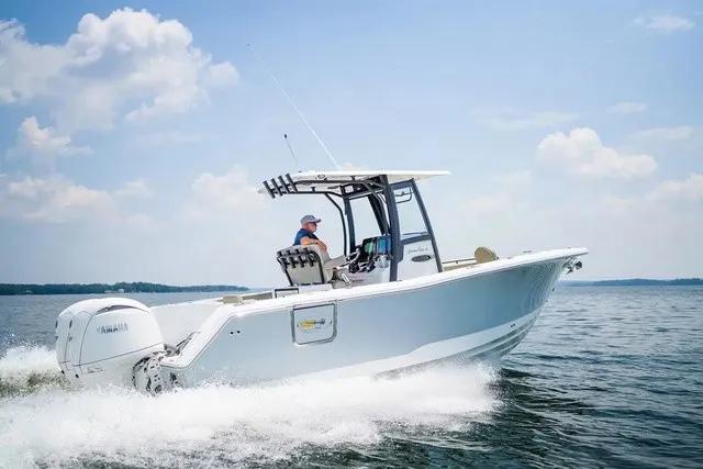 Slide: The Image of A 2027 Sea Hunt Gamefish 25 boat speeds across the water. It features a white hull and T-top. - 3