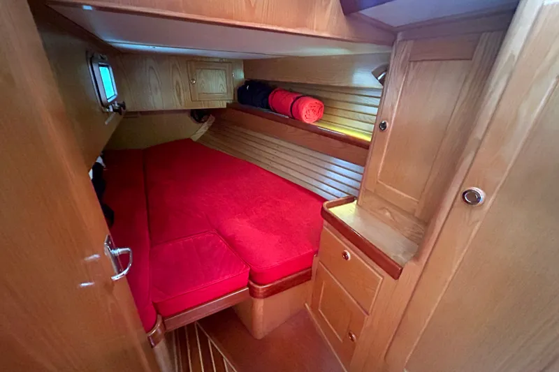 Slide: The Image of Cozy cabin interior of 1993 Alden 43 yacht with red bedding and wooden finish. - 19