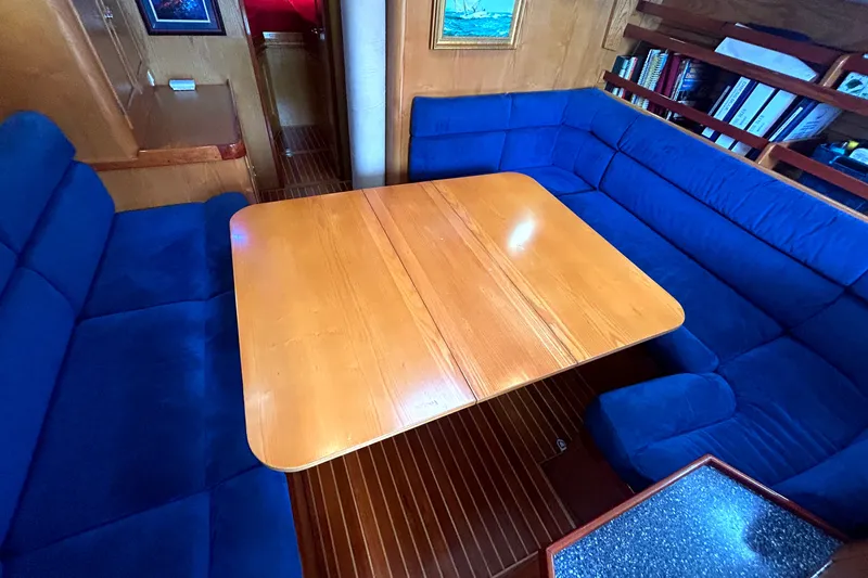 Slide: The Image of Cozy dining area with blue seating and wooden table on a 1993 Alden 43 yacht. - 11