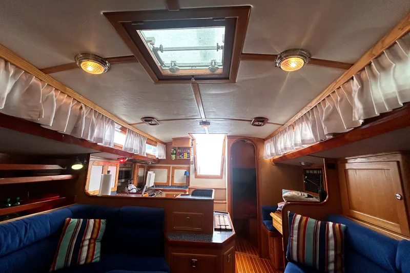 Slide: The Image of Interior of a 1993 Alden 43 sailboat with cozy seating and wooden accents. - 17