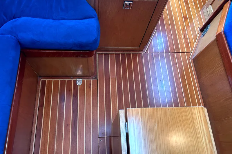 Slide: The Image of Teak interior of 1993 Alden 43 yacht with blue upholstery and wooden cabinetry. - 13