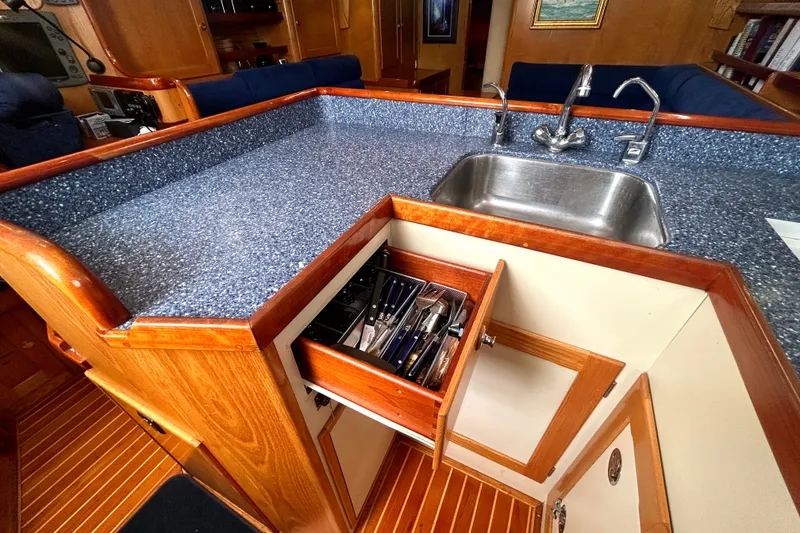 Slide: The Image of Interior of 1993 Alden 43 yacht kitchen with blue countertop and open utensil drawer. - 6