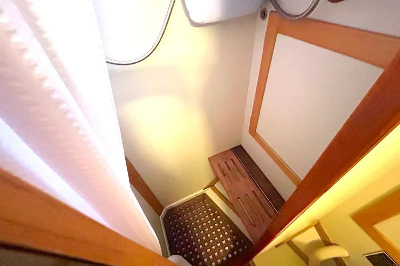 Slide: The Image of Compact shower area in a 1993 Alden 43 yacht, featuring wooden bench and curtain. - 25