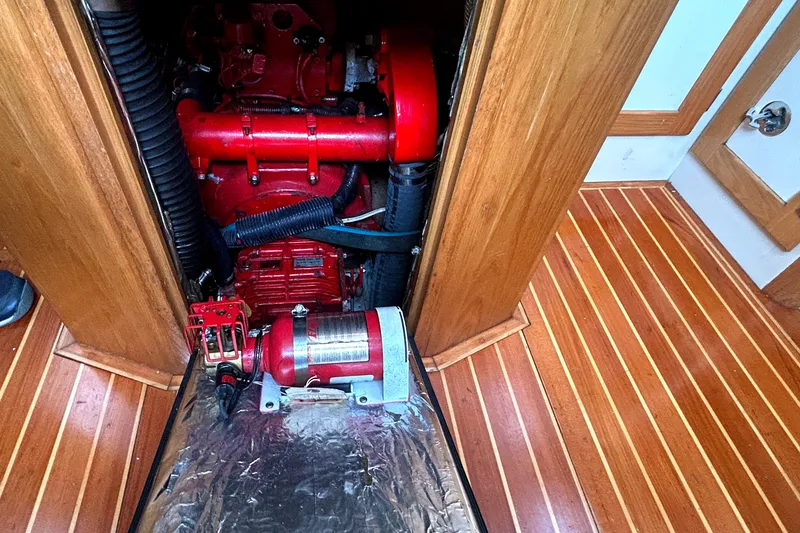 Slide: The Image of Engine compartment of a 1993 Alden 43 yacht with red machinery and wooden flooring. - 22