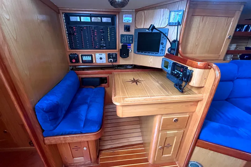 Slide: The Image of Navigation station in a 1993 Alden 43 yacht with blue cushions and control panels. - 15