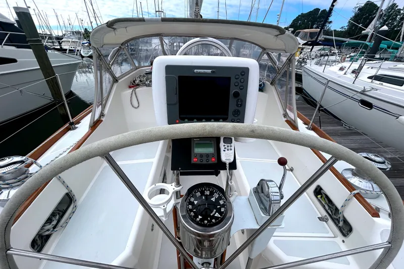 Slide: The Image of Cockpit of a 1993 Alden 43 sailboat with navigation equipment and steering wheel. - 27