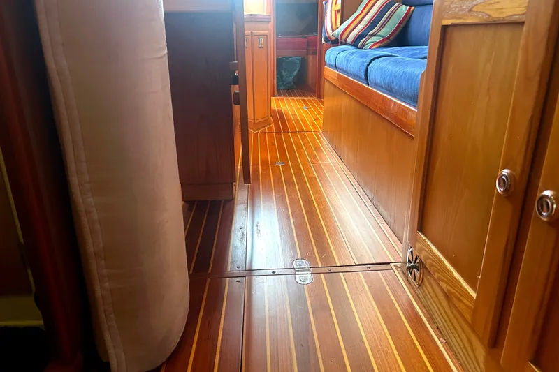 Slide: The Image of Interior of a 1993 Alden 43 yacht with polished wooden flooring and seating. - 18