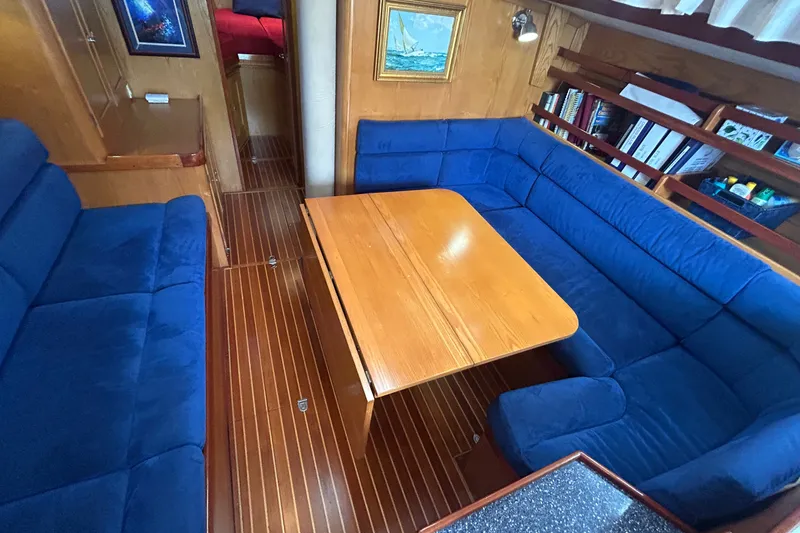 Slide: The Image of Interior of 1993 Alden 43 yacht with blue seating and wooden table. - 16