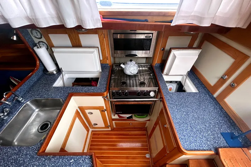 Slide: The Image of Galley kitchen in 1993 Alden 43 yacht with stove, sink, and storage compartments. - 5