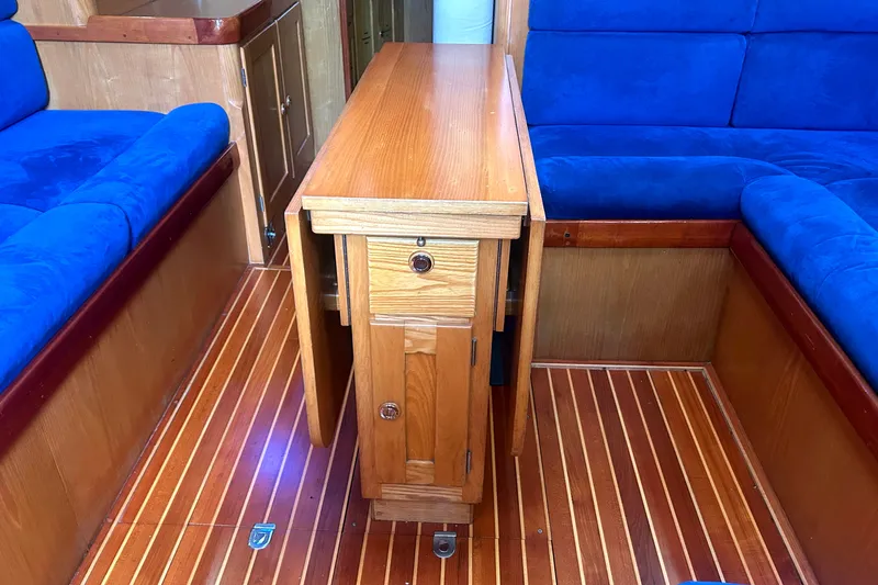 Slide: The Image of Interior of 1993 Alden 43 yacht with wooden table and blue seating. - 17