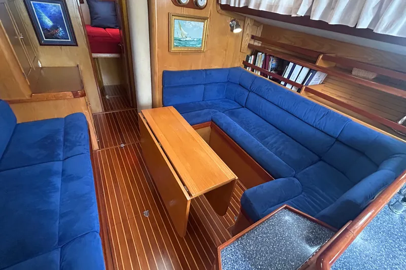 Slide: The Image of Luxurious 1993 Alden 43 yacht interior with blue seating, wooden table, and nautical decor. - 8