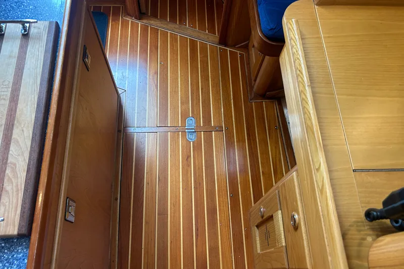 Slide: The Image of Wooden interior of a 1993 Alden 43 yacht, featuring polished flooring and cabinetry. - 14