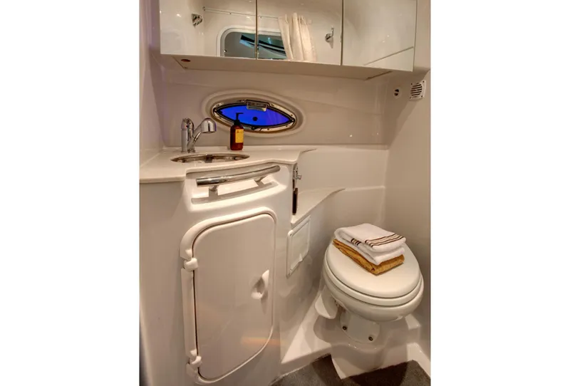 Slide: The Image of Manufacturer Provided Image: 2016 Four Winns V335 boat bathroom with sink, toilet, and storage cabinets. - 11