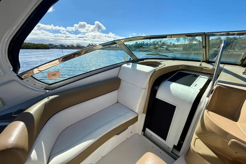 Slide: The Image of 2016 Four Winns V335 boat interior with seating, overlooking serene water and blue sky. - 4
