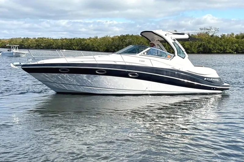 The Image of A sleek, white Four Winns motorboat, model V335, year 2016, on calm water. - 0