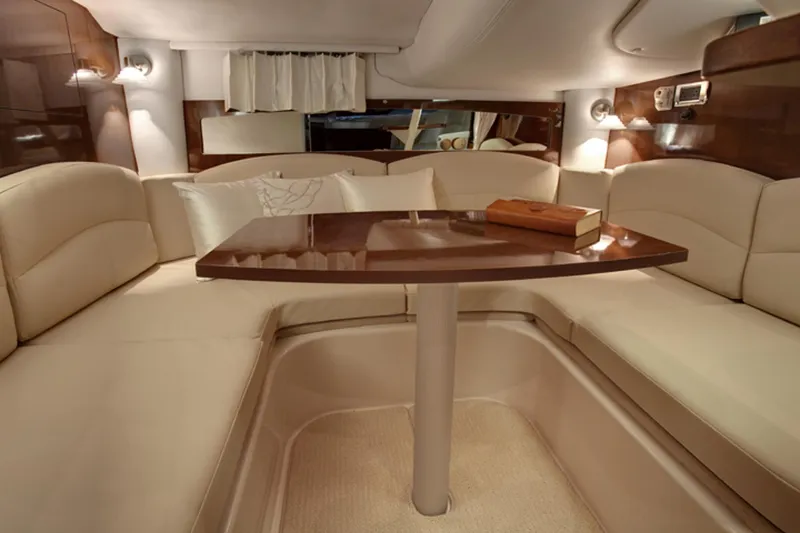 Slide: The Image of Manufacturer Provided Image: 2016 Four Winns V335 cabin interior with beige seating and wooden table. - 9