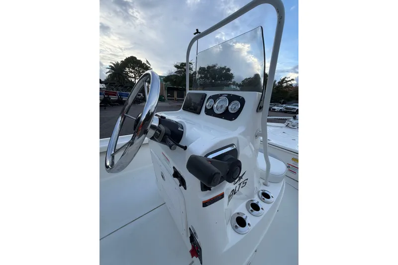 Slide: The Image of 2025 Mako 18 LTS boat console with steering wheel and gauges under cloudy sky. - 3
