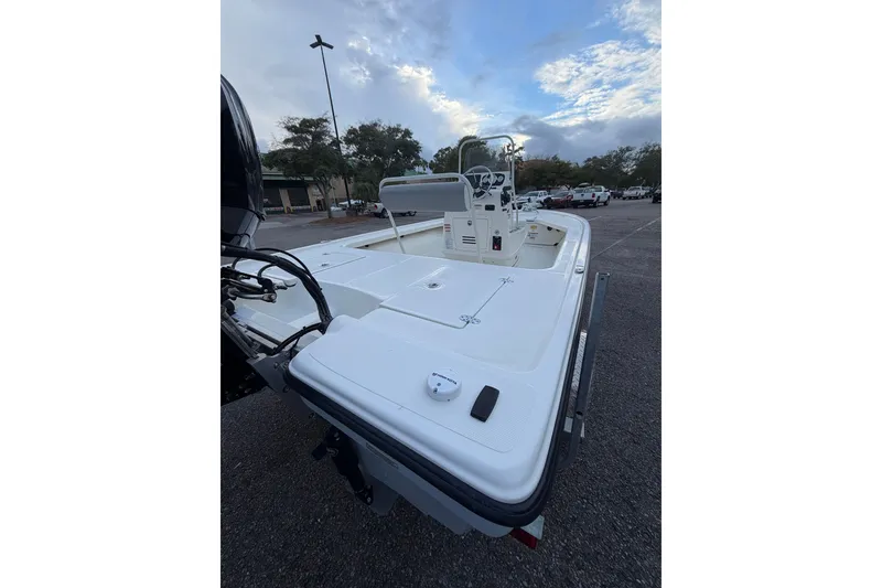 Slide: The Image of 2025 Mako 18 LTS boat in parking lot, showcasing spacious deck and steering console. - 5