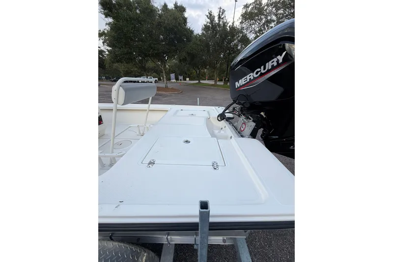 Slide: The Image of 2025 Mako 18 LTS boat with Mercury engine, parked outdoors. - 7