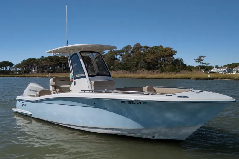Slide: The Image of 2024 Scout 240 XSF boat on calm water with scenic background. - 2