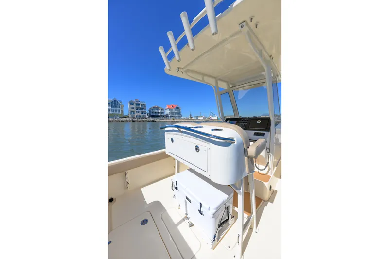 Slide: The Image of 2024 Scout 240 XSF boat interior with helm station and waterfront view. - 7