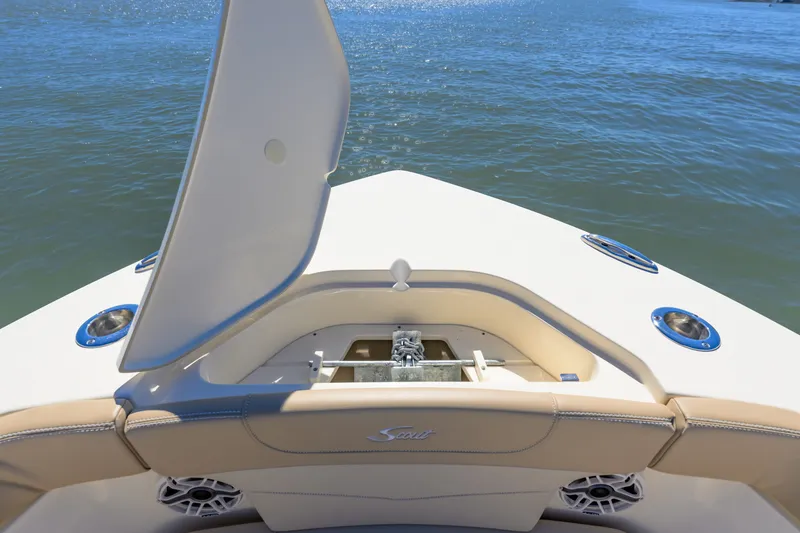 Slide: The Image of 2024 Scout 240 XSF boat bow with open anchor compartment on calm water. - 16