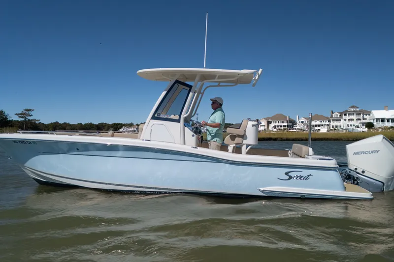 The Image of 2024 Scout 240 XSF boat cruising on water with Mercury engine, clear sky background. - 0