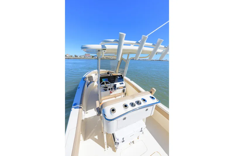 Slide: The Image of 2024 Scout 240 XSF boat on water, showcasing helm and fishing rod holders. - 5