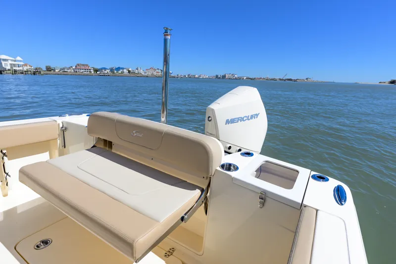 Slide: The Image of 2024 Scout 240 XSF boat with Mercury engine, beige seating, and ocean view. - 15