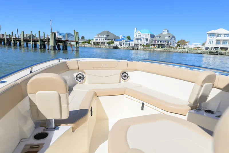Slide: The Image of 2024 Scout 240 XSF boat interior with waterfront view and luxury seating. - 13