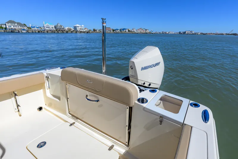 Slide: The Image of 2024 Scout 240 XSF boat with Mercury engine, docked near waterfront homes. - 14