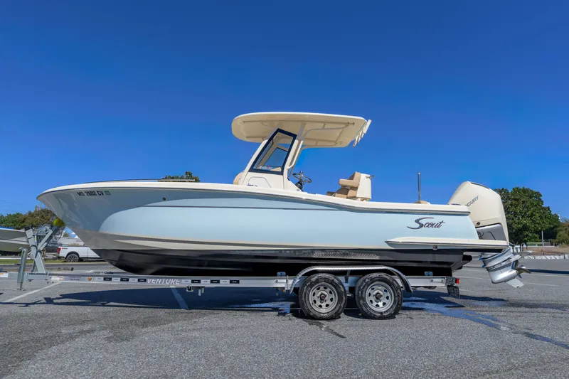 Slide: The Image of 2024 Scout 240 XSF boat on trailer under clear blue sky. - 18