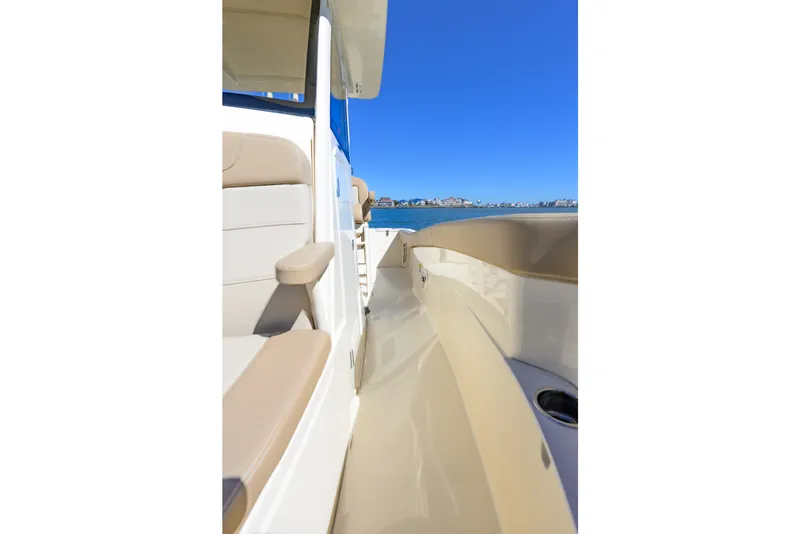 Slide: The Image of 2024 Scout 240 XSF boat deck with beige seating, ocean view. - 11