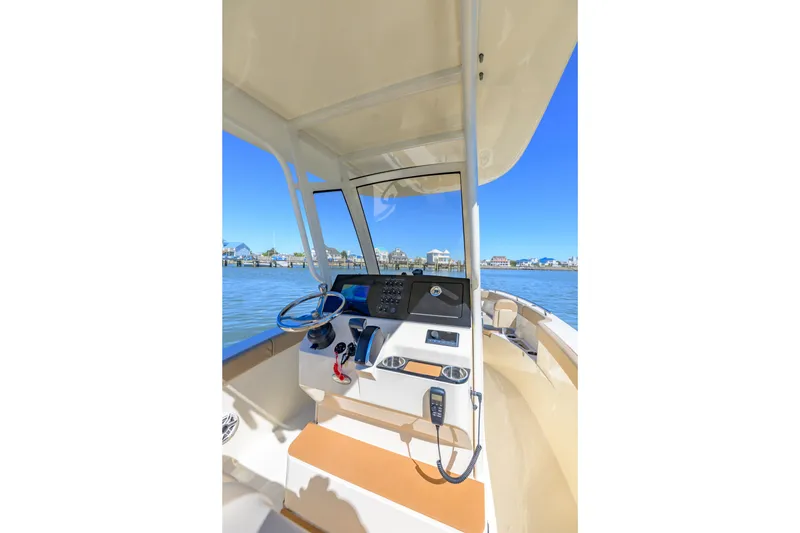 Slide: The Image of 2024 Scout 240 XSF boat cockpit with steering wheel and control panel on water. - 6