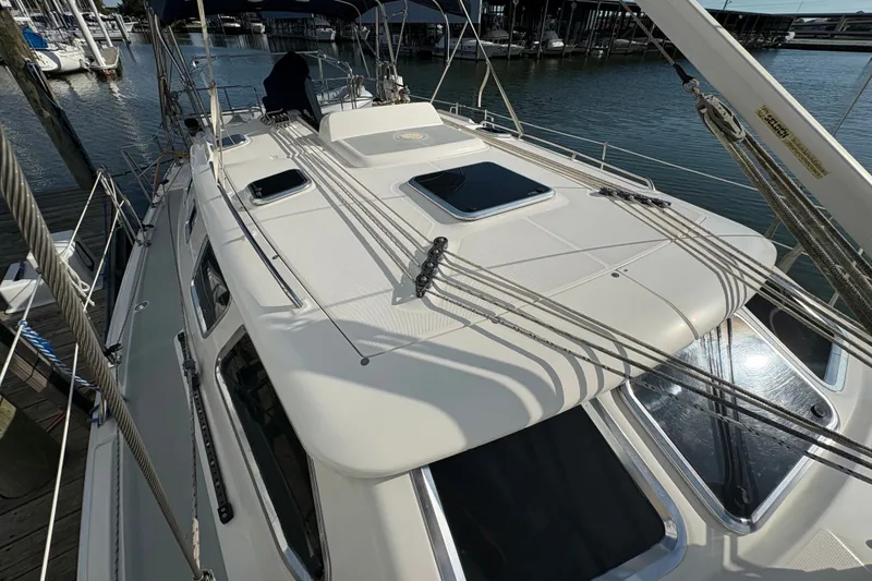 Slide: The Image of 2007 Hunter 41 Deck Salon sailboat docked, showcasing sleek deck design and rigging. - 10