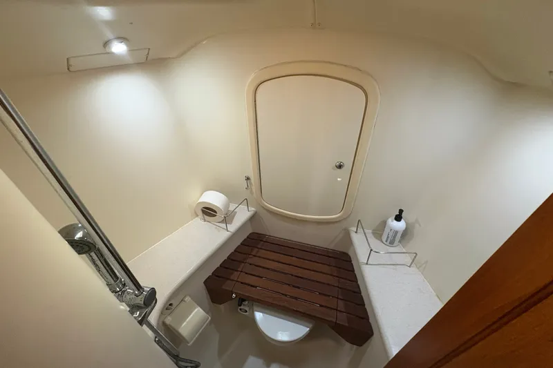 Slide: The Image of Bathroom interior of 2007 Hunter 41 Deck Salon yacht, featuring shower and wooden seat. - 24