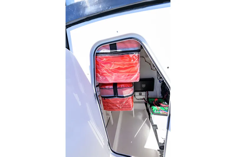 Slide: The Image of Interior storage compartment of 2025 Delta Boatworks D245, featuring organized red storage bags. - 17