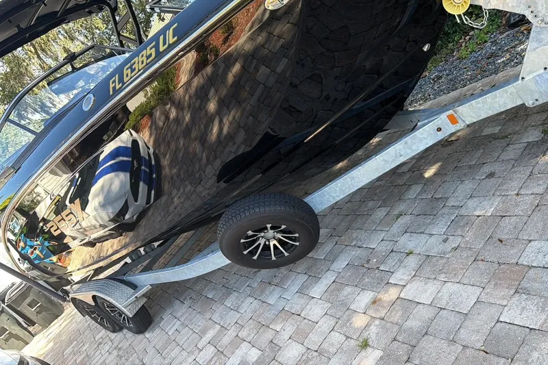 Slide: The Image of 2026 Ymaha 255 boat on trailer, black exterior, parked on brick driveway. - 5