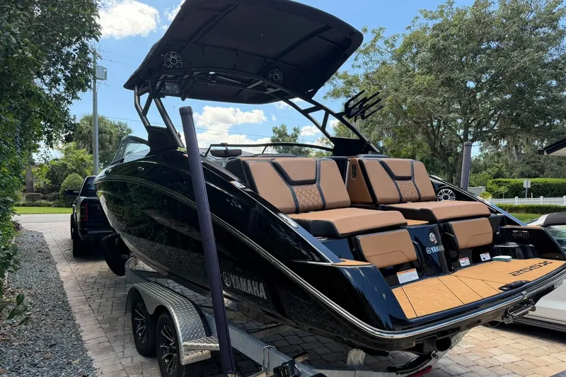 Slide: The Image of 2026 Yamaha 255 boat on trailer, sleek black design, parked outdoors. - 3