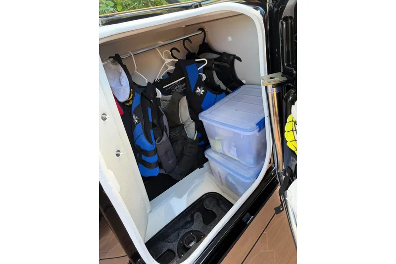 Slide: The Image of Storage compartment in 2026 Ymaha 255 boat with life jackets and plastic bins. - 9