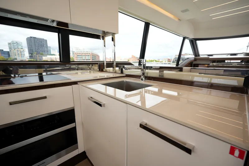 Slide: The Image of Modern kitchen interior on 2023 Prestige 690 yacht with sleek countertops and city view. - 56
