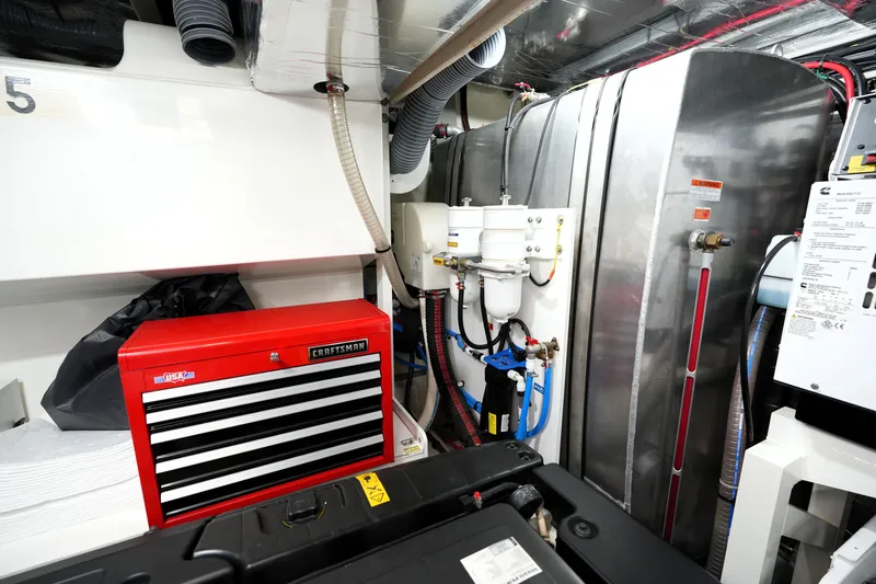 Slide: The Image of Engine room of 2023 Prestige 690 yacht with red tool chest and machinery. - 129