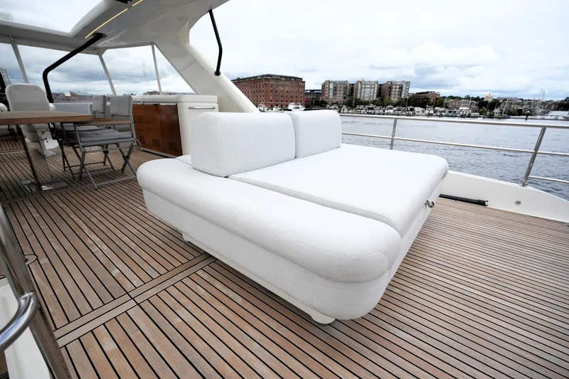 Slide: The Image of Luxurious 2023 Prestige 690 yacht deck with elegant white seating and scenic waterfront view. - 33