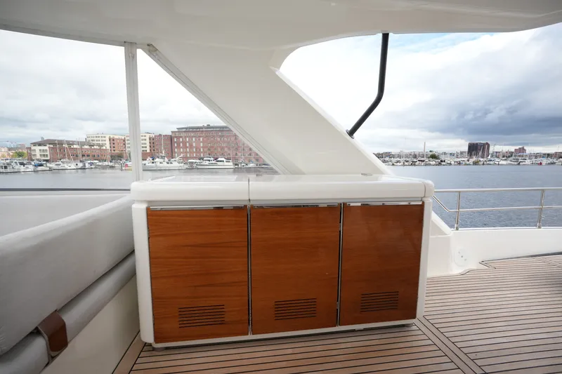 Slide: The Image of Luxurious 2023 Prestige 690 yacht deck with sleek wooden cabinetry and waterfront view. - 38